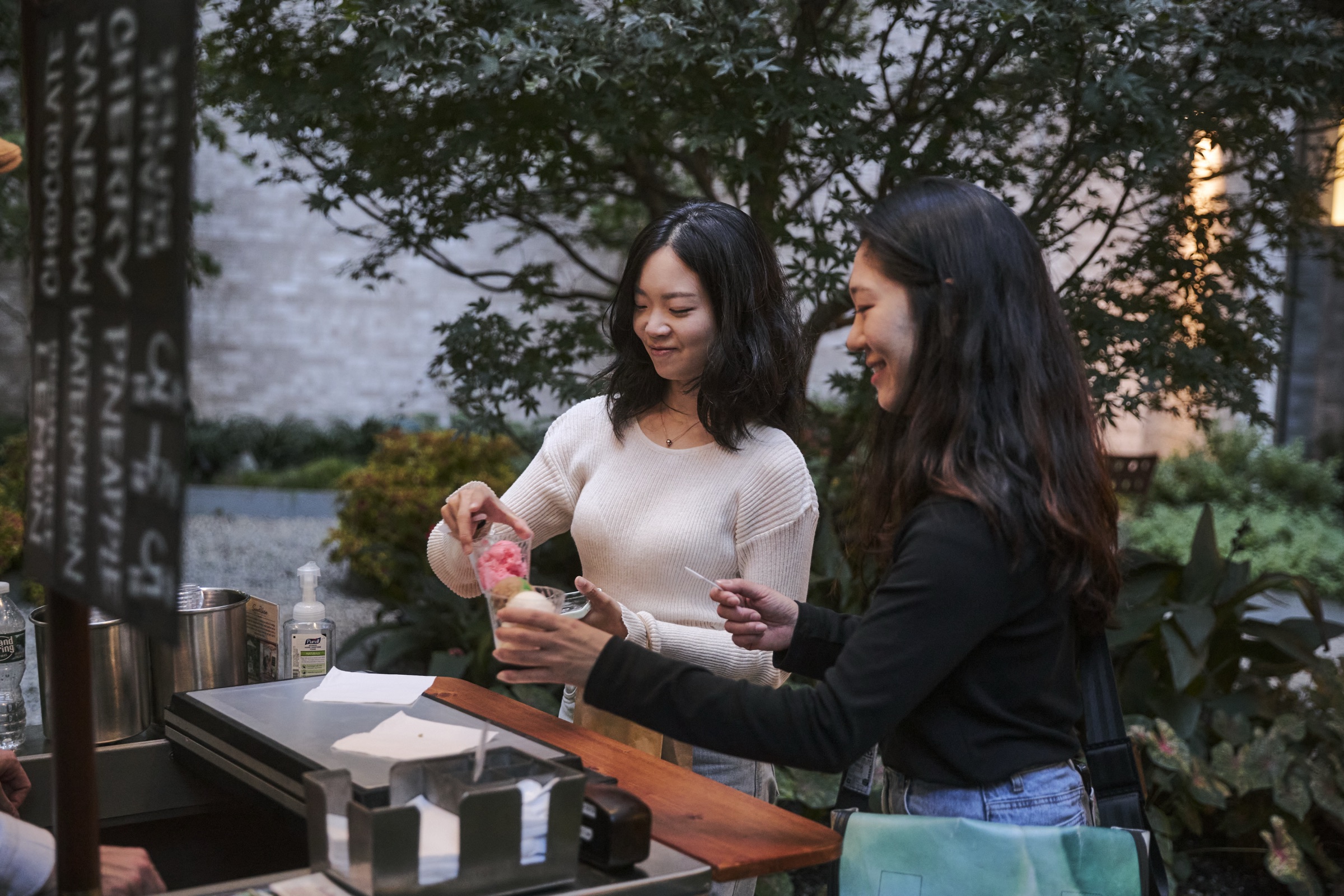 Deux femmes versant des smoothies à un bar à jus extérieur
